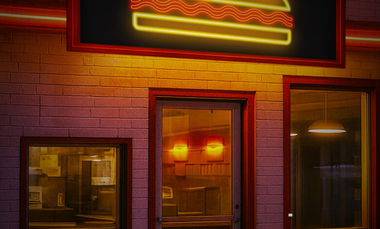 An empty diner lit by neon lights at night