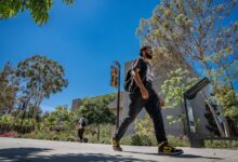 Student walking on campus walkway.