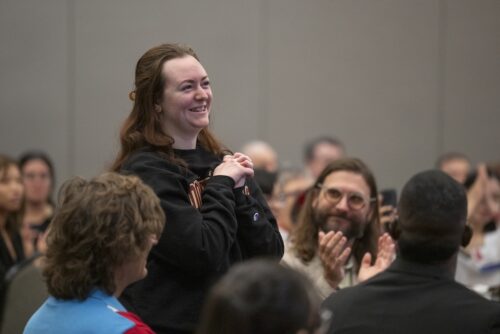 Woman standing and smiling in audience