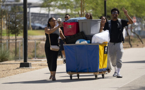 A Toro student and family push a heavily loaded cart toward the residence hall.