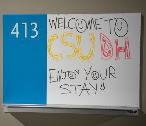 A whiteboard with the message "Welcome to CSUDH. Enjoy Your Stay!"