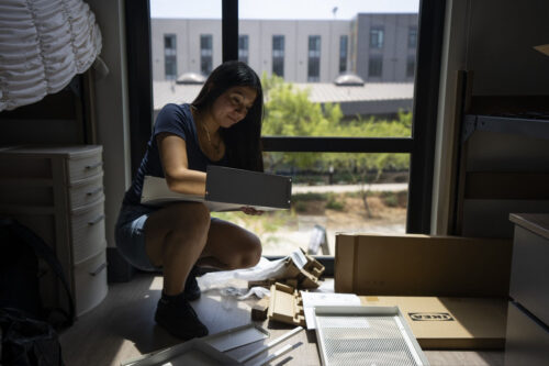 A student puts together new furniture.
