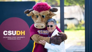 President Villarreal hugging Teddy Toro in front of a CSUDH sign